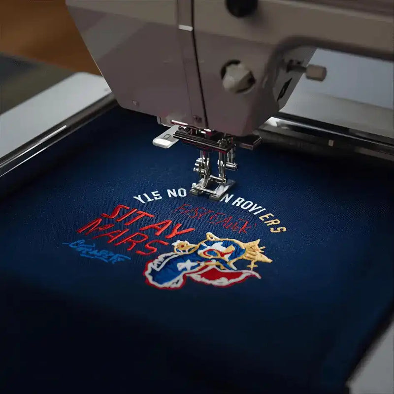 Embroidery machine in operation on a blue fabric.