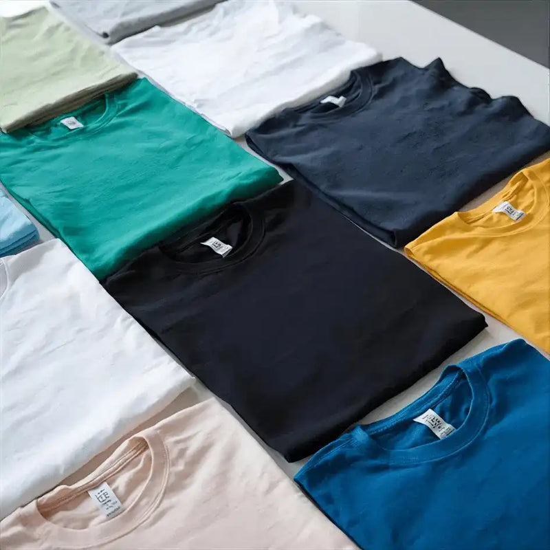 A variety of colorful folded short-sleeve crew-neck t-shirts.