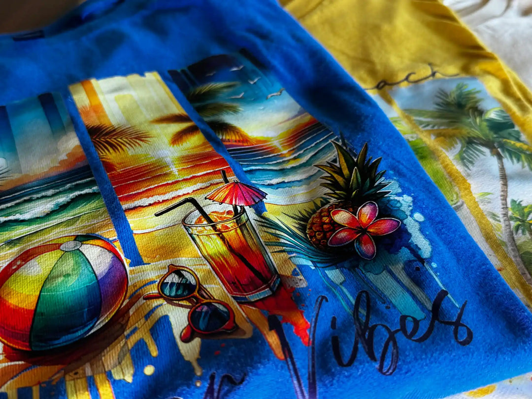 Blue and yellow t-shirts with vibrant beach-themed graphics.