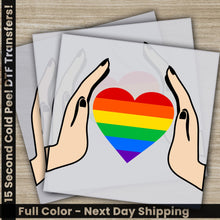 Load image into Gallery viewer, a pair of hands holding a rainbow heart
