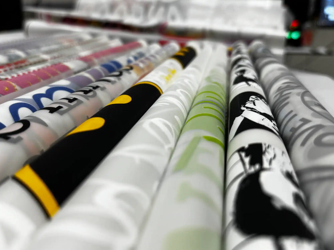 Multiple rolls of patterned fabric in various colors and designs.