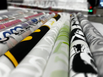 Multiple rolls of patterned fabric in various colors and designs.