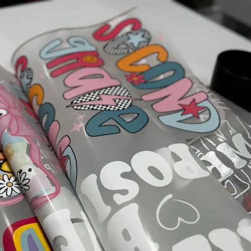 Rolls of transparent film with colorful and white graphic designs.