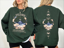 Load image into Gallery viewer, a woman wearing a green sweatshirt with mountains and stars on it
