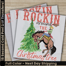 Load image into Gallery viewer, a christmas card with a cowboy riding a horse next to a christmas tree